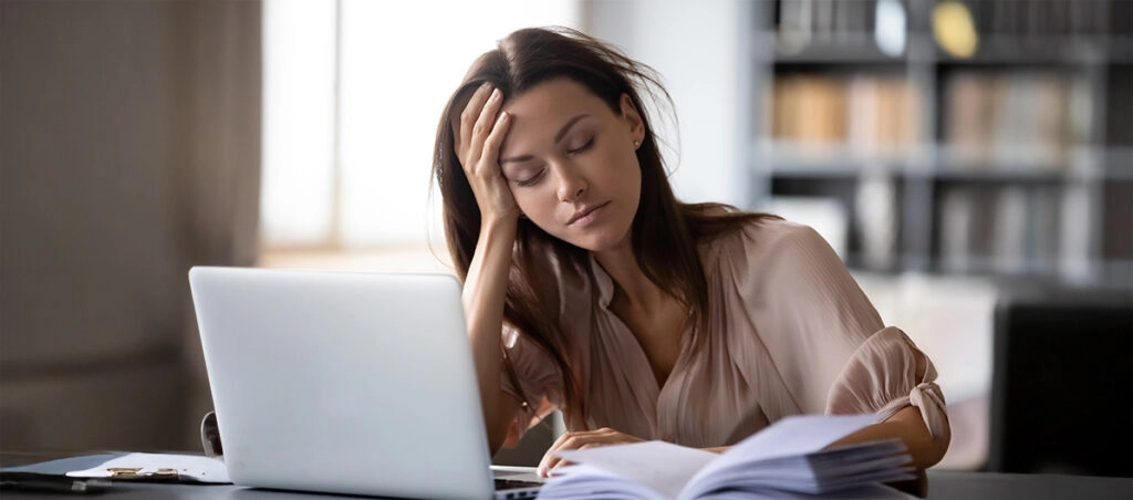 Mujer dormida delante del ordenador por cansancio primaveral
